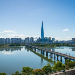 Modern cityscape with a tall skyscraper and bridge over river